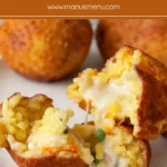 Fried rice balls cut open to show melted cheese, ham and peas inside.