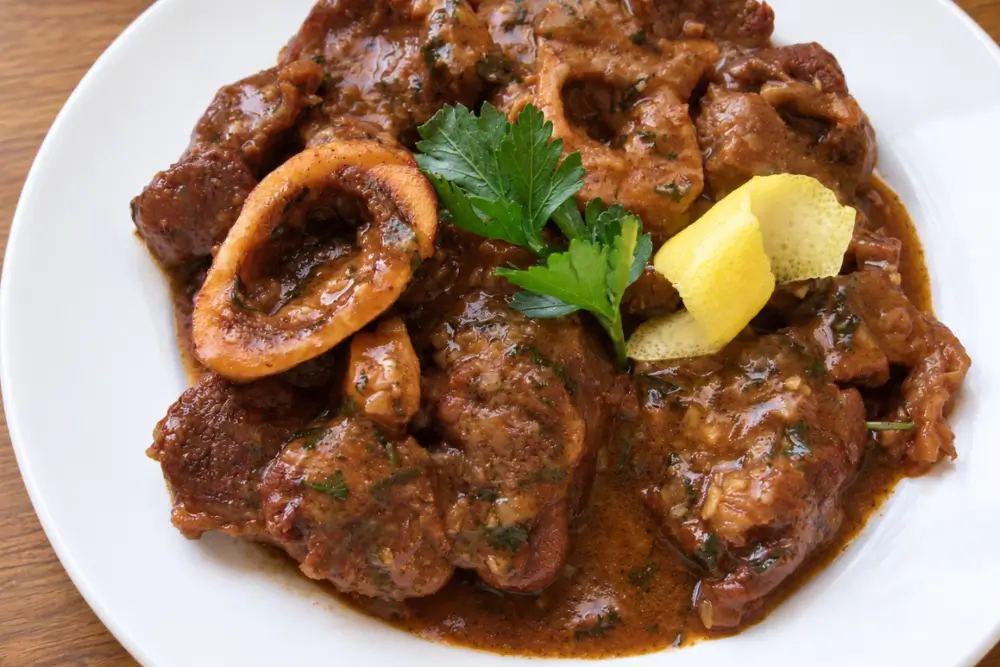 Ossobuco Milanese with tender braised veal shanks, rich sauce, parsley and lemon garnish.
