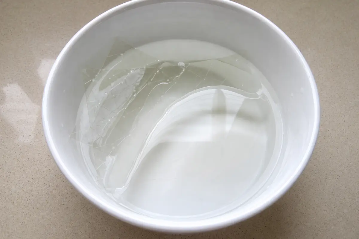 Gelatine sheets soaking in cold water until softened.