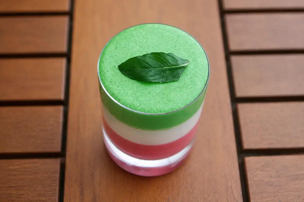 Tricolore panna cotta finished with a fresh mint leaf garnish.