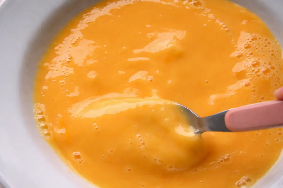 Eggs and milk being whisked together until smooth and slightly frothy.