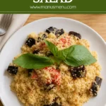 Couscous Salad served on a white plate and garnished with fresh basil leaves.