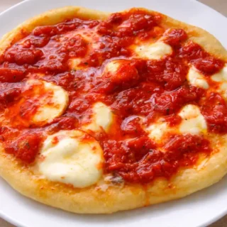 Fried pizza with melted mozzarella and tomato sauce on a golden base.