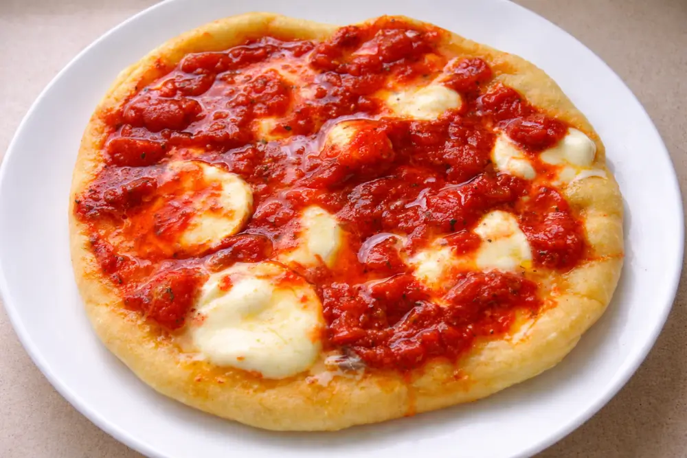 Fried Pizza Fried pizza with melted mozzarella and tomato sauce on a golden base.