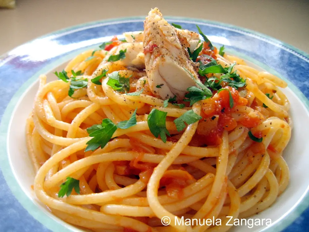 Bowl of fish sauce pasta with cooked fish on top.