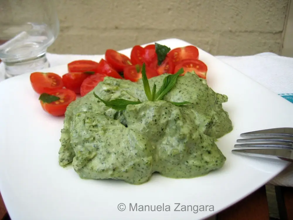Chicken in mint mayonnaise with cherry tomatoes on a plate.