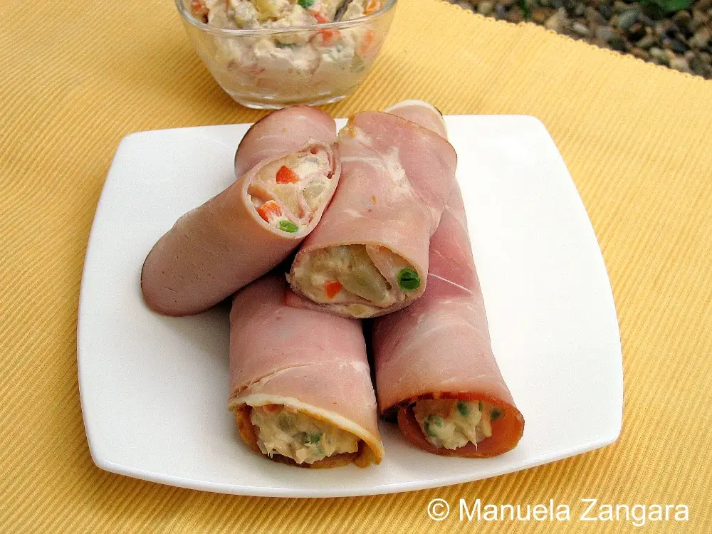 Russian Salad wrapped in ham slices and arranged neatly on a plate.