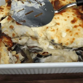 Freshly baked crespelle with creamy béchamel and golden top in a dish.