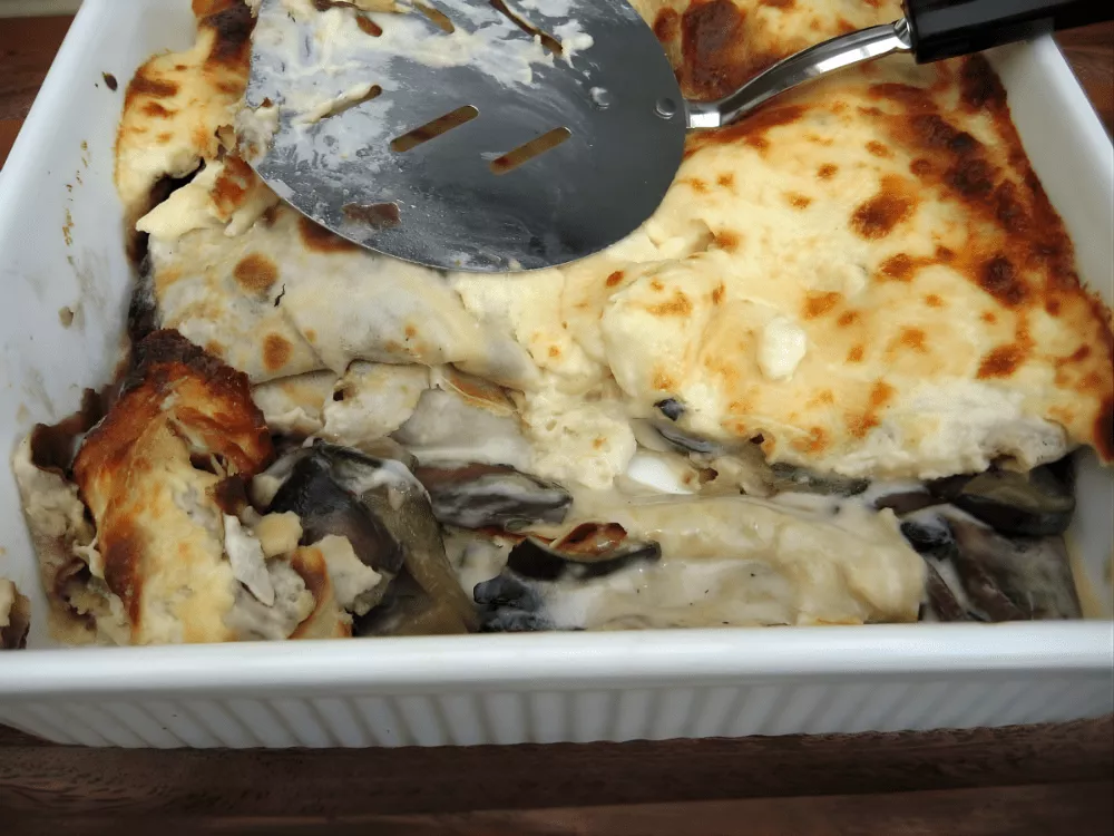 Freshly baked crespelle with creamy béchamel and golden top in a dish.