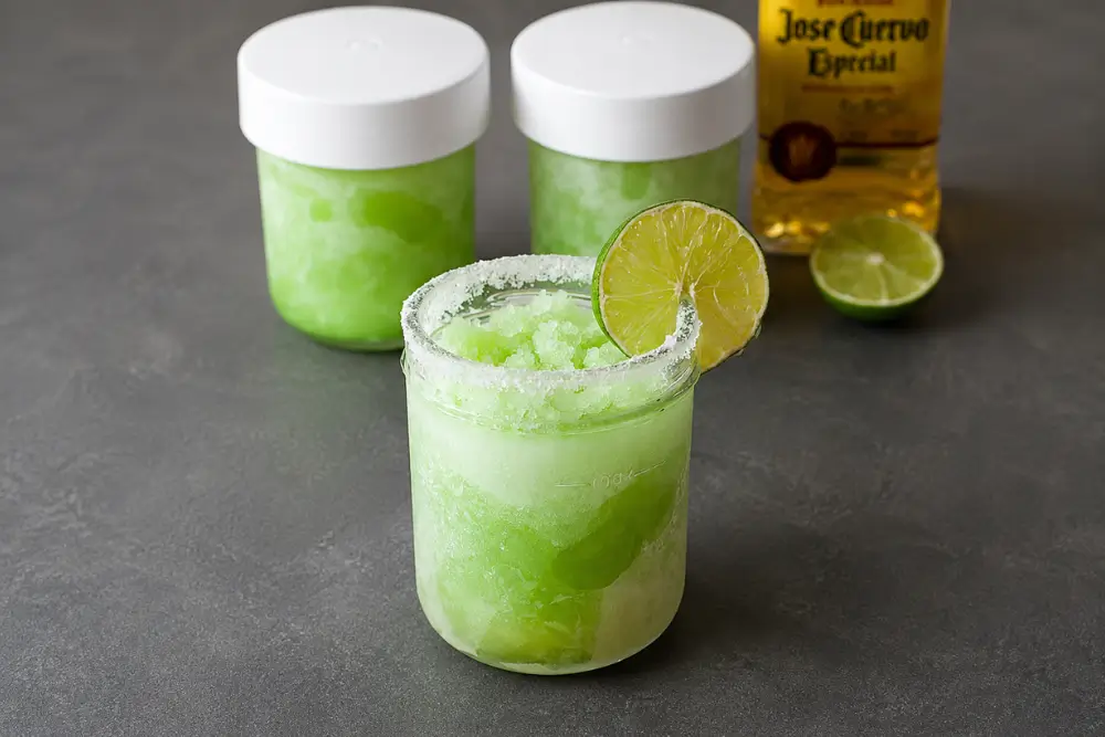 Frozen margarita in a salted glass with lime garnish, ready to serve.