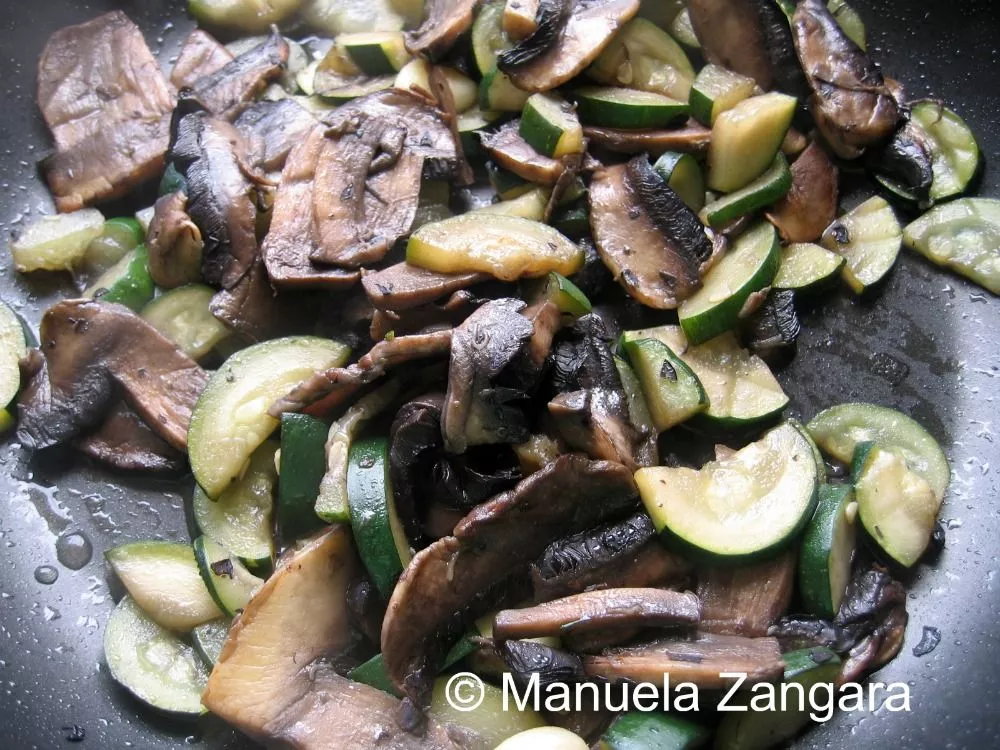 Zucchini and mushrooms sautéing in olive oil.