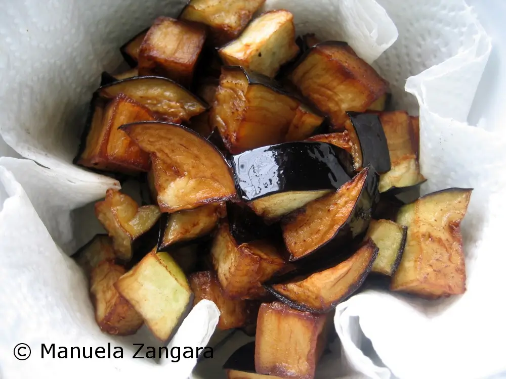 Fried eggplant cubes draining on paper towel.