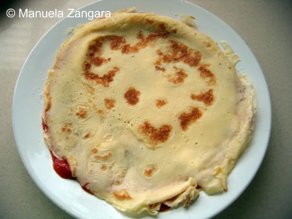 Frittatina topped with tomato sauce and grated Parmigiano before adding the next layer.