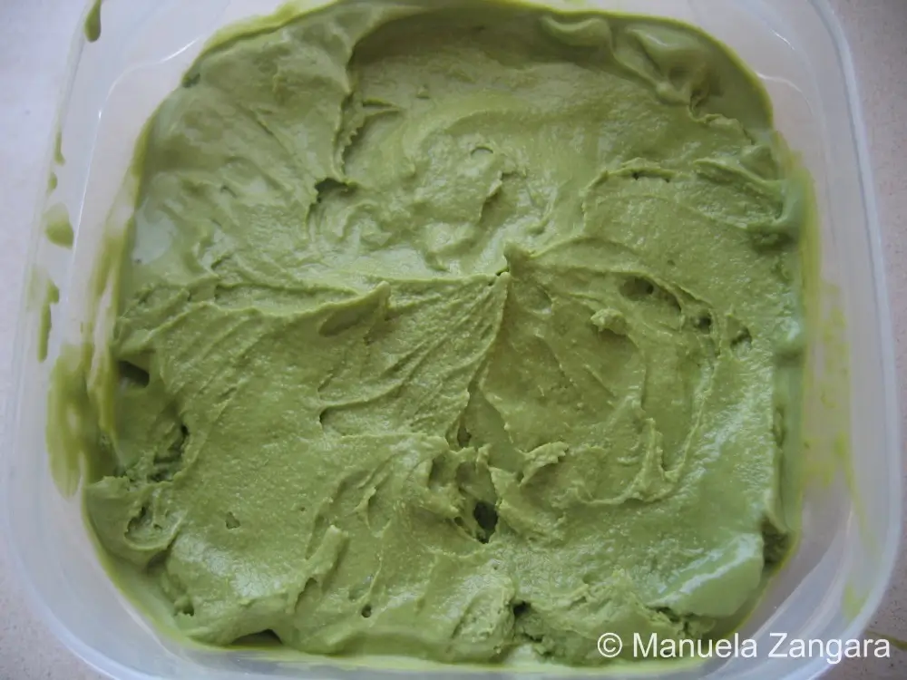 Freshly churned green tea ice cream spread in a storage container.