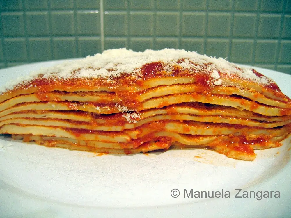 Cross-section slice showing thin frittatine layers with tomato sauce and Parmigiano.