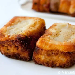 Close-up of crispy crostini filled with rich meat sauce and melted cheese.