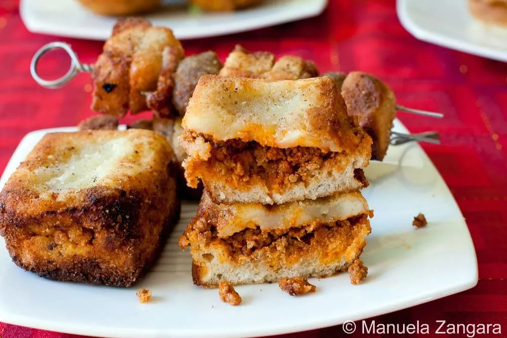 Crostini Fried crostini stacked with layers of meat sauce and cheese.