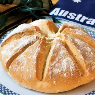 Homemade damper bread served beside an Australian flag and ribbons.