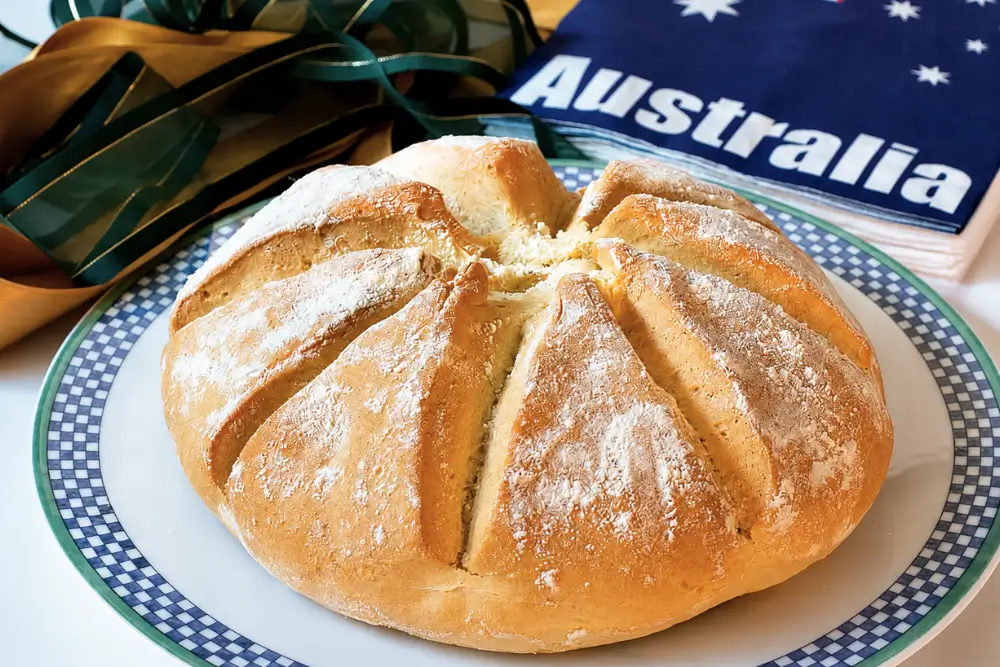 Homemade damper bread served beside an Australian flag and ribbons.