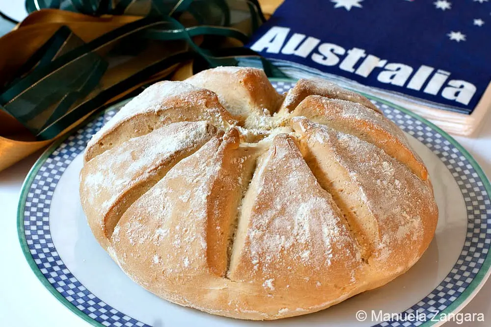 Close-up of the baked Damper loaf with visible scoring and dusted flour.