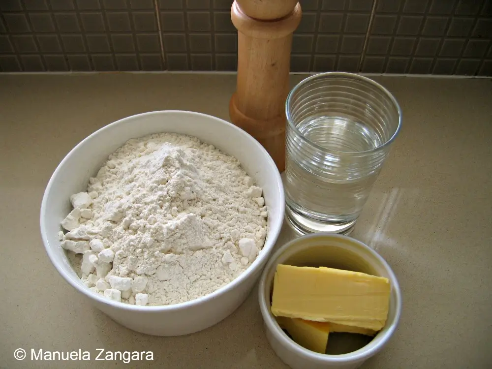 Basic Damper ingredients arranged on the counter, including flour, butter, water, and salt.