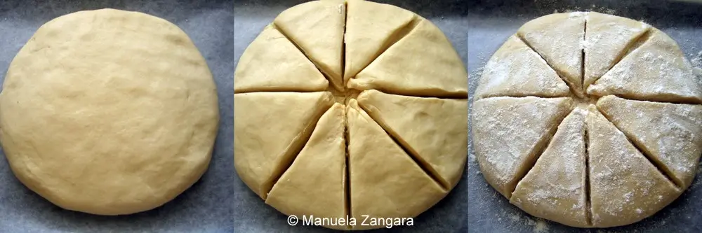 Dough shaped into a round loaf, scored into wedges and dusted with flour.