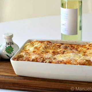 Baked pasta rolls in a rectangular dish with lightly browned cheese topping