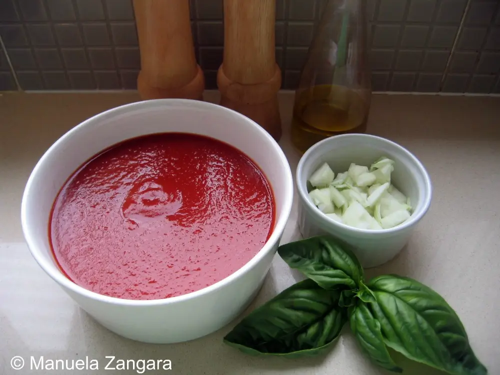 Tomato purée, basil, onion, and olive oil prepared for the sauce.