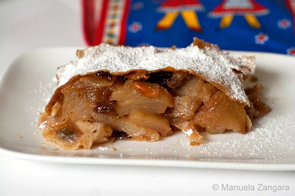 Close-up of apple strudel slice showing apple and raisin filling.