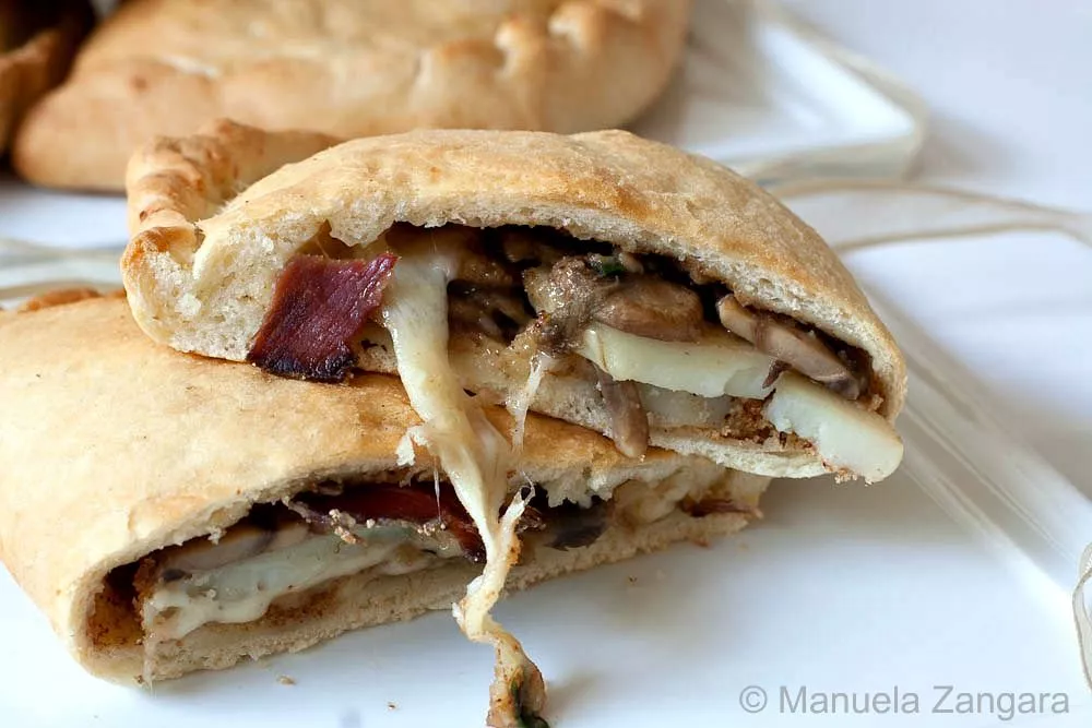Sliced Mushroom and Asiago Calzoni on a plate.