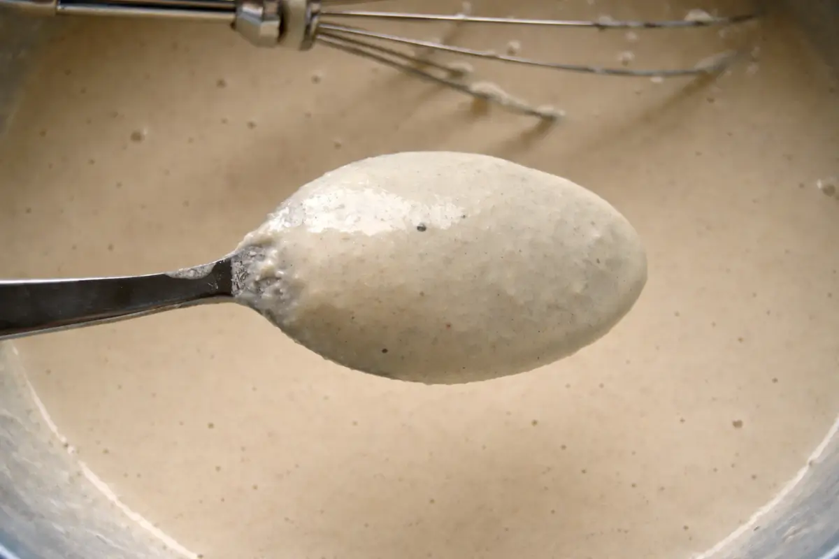 Batter flowing smoothly from a spoon.