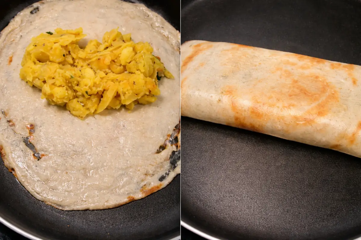 Dosa spread thinly on a tawa with spiced potato masala added in the centre and folded to cook.