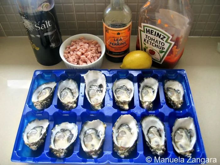 Ingredients for Oysters Kilpatrick including oysters, bacon, ketchup, Worcestershire sauce, lemon, and salt.