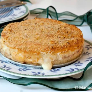 Whole Gattò di Patate on a serving plate with a crisp golden crust.