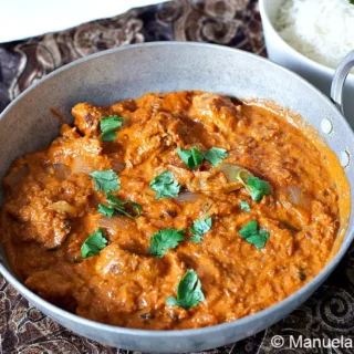 Chicken tikka masala finished in pan with coriander on top.