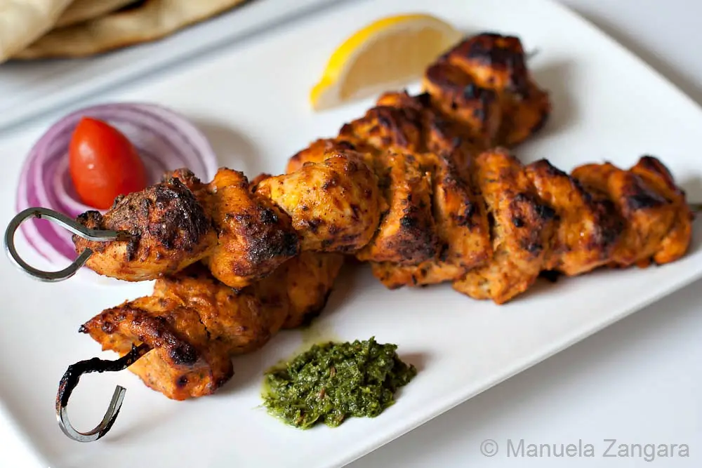 Chicken Tikka Cooked chicken tikka skewers served with chutney, lemon, and onions.