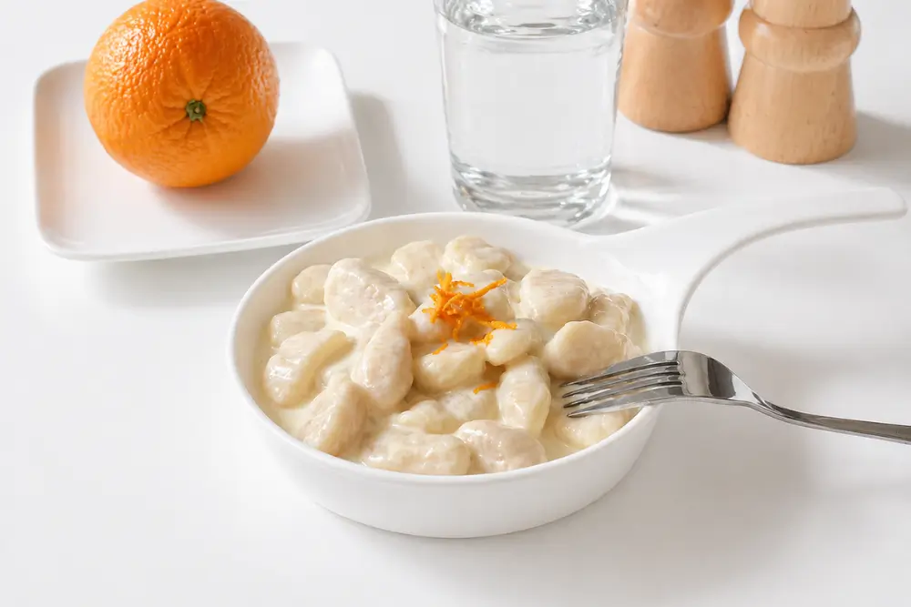 Homemade potato gnocchi coated in creamy taleggio sauce with orange zest.