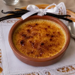 Crème brûlée with a crisp caramelised sugar topping served in a terracotta ramekin.