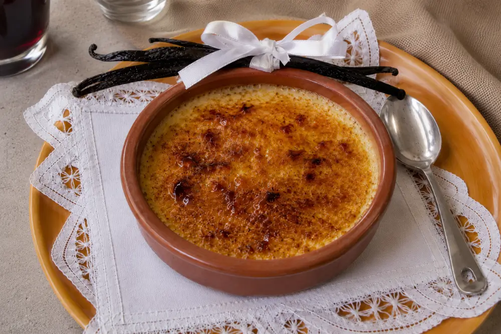Crème brûlée with a crisp caramelised sugar topping served in a terracotta ramekin.