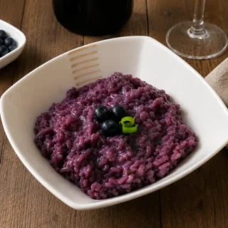 Blueberry Risotto served in a white bowl with fresh blueberries and sliced green onion.