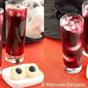 Two glasses of Halloween Punch beside a plate of lychee blueberry eyeballs.