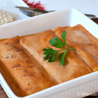 Hortobágyi palacsinta arranged in a baking dish with sauce on top.