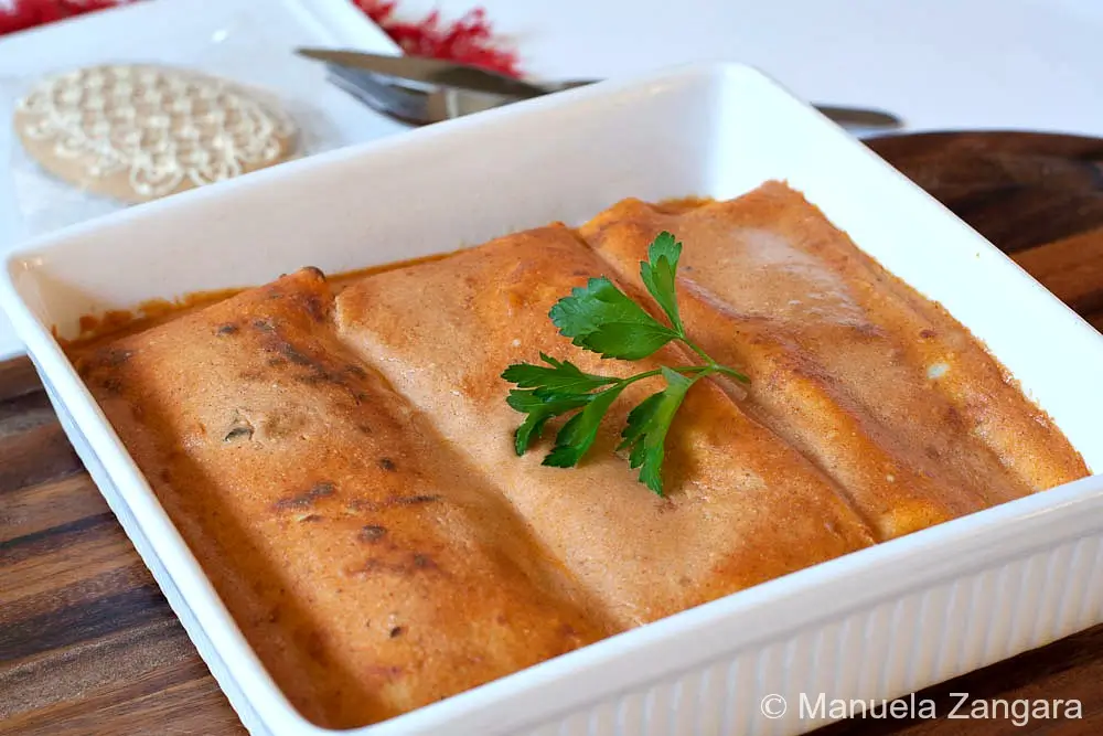 Hortobágyi palacsinta Hortobágyi palacsinta arranged in a baking dish with sauce on top.