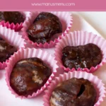 Marrons glacés arranged in paper cups with a glossy sugar coating.