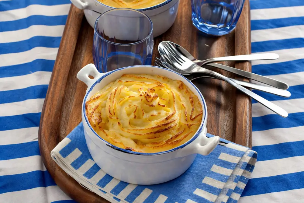 Golden mashed potato topping with a crisp surface over a rich minced lamb filling.