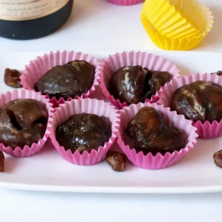 Marrons glacés arranged in paper cups with a glossy sugar coating.