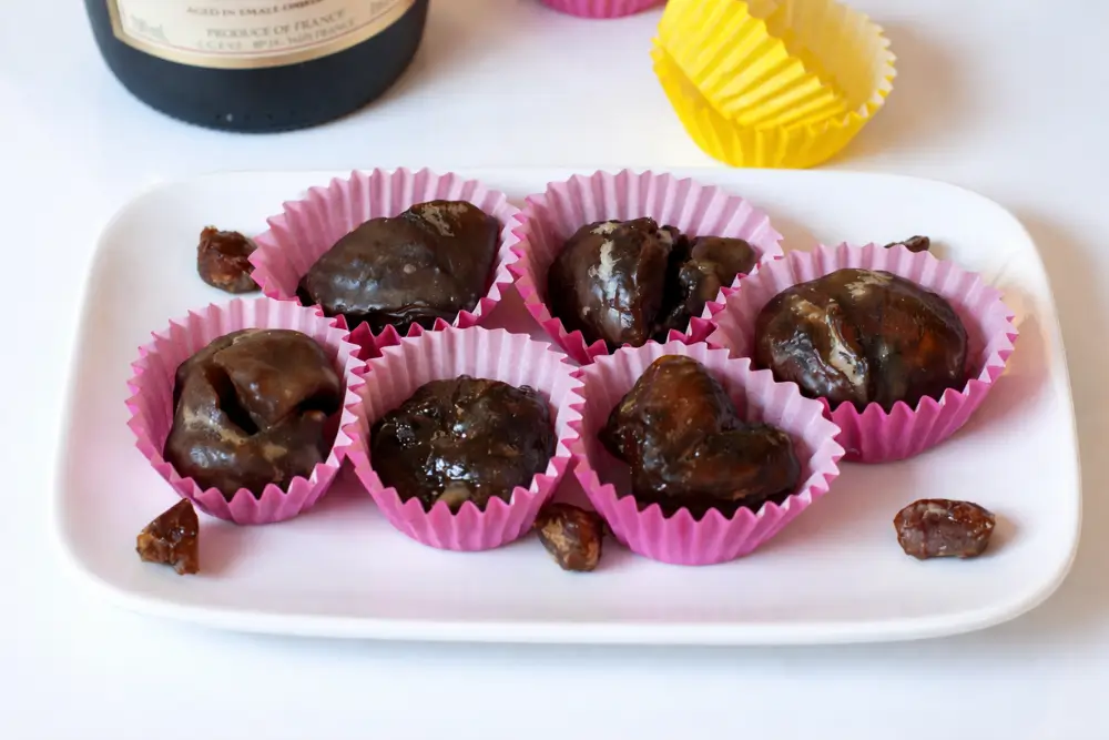 Marrons glacés arranged in paper cups with a glossy sugar coating.