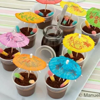 Close-up of Muddy Puddle Cups with colourful paper umbrellas and fizzy worms.