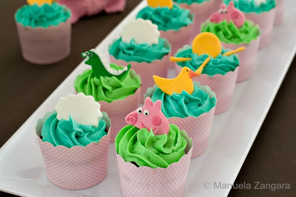 Peppa Pig Chocolate & Vanilla Cupcakes Close-up view of Peppa Pig cupcakes with colourful icing and fondant decorations.