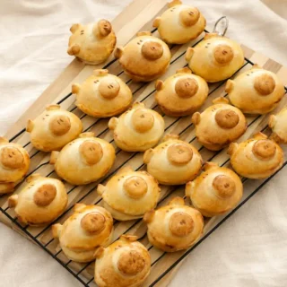 Golden Pizza Flavoured Piggy Buns cooling on a wire rack.